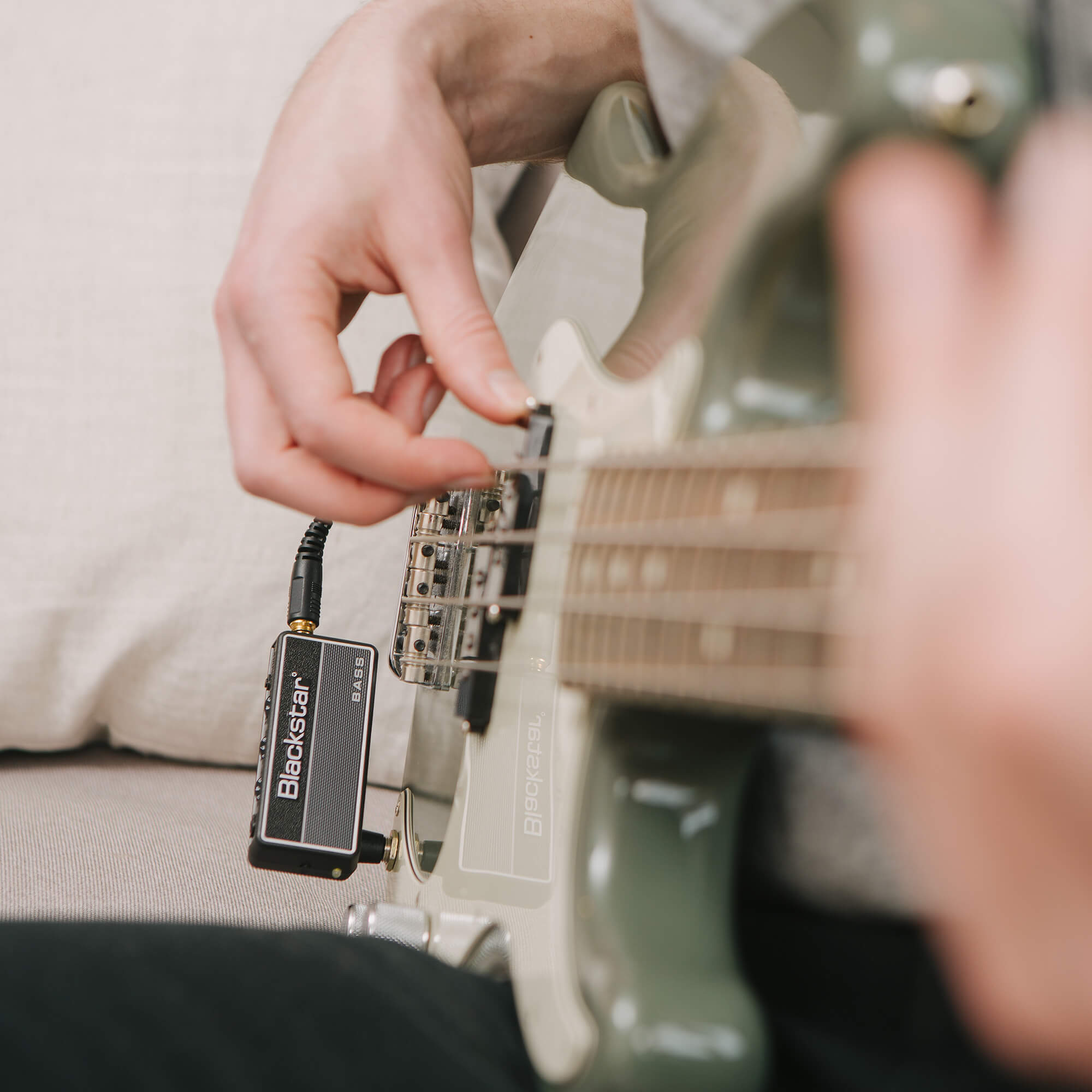 musician playing electric bass with Blackstar amplug 2 FLY Bass amp plugged into electric bass and headphones