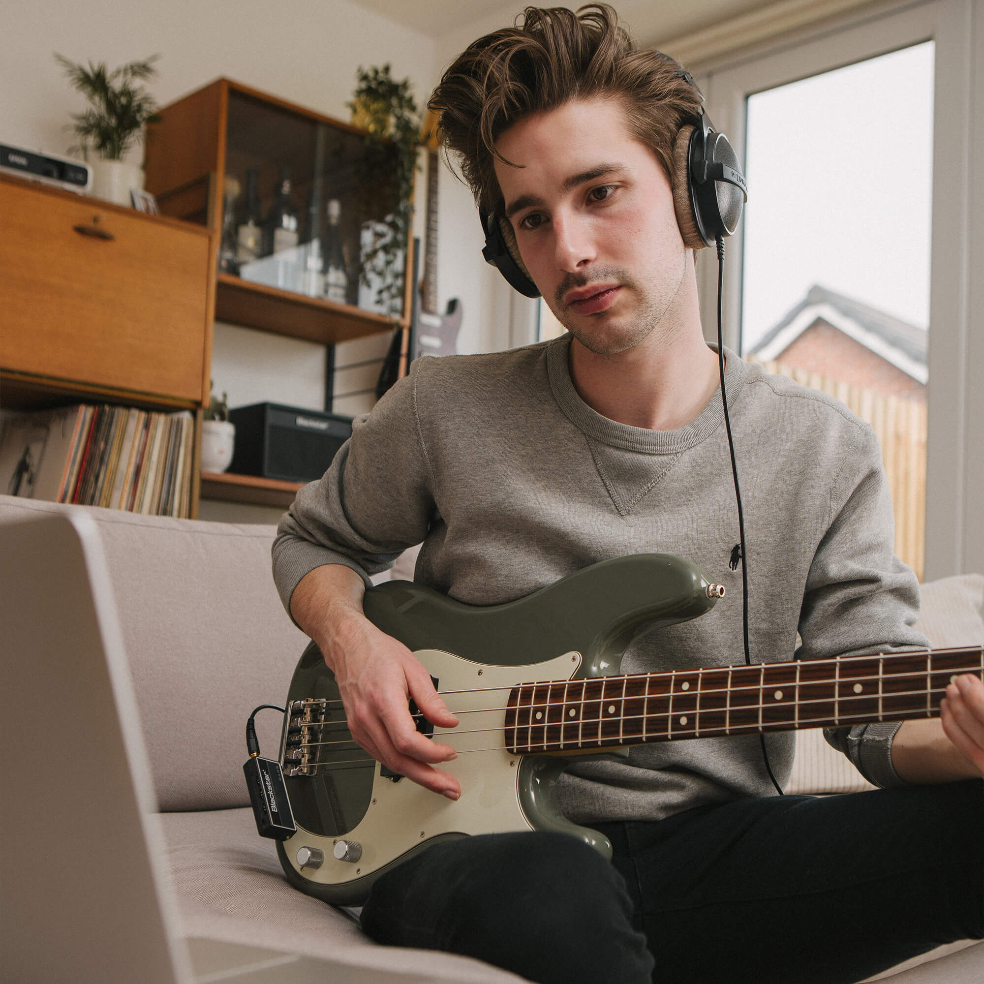 musician playing electric bass with Blackstar amplug 2 FLY Bass amp plugged into electric bass and headphones