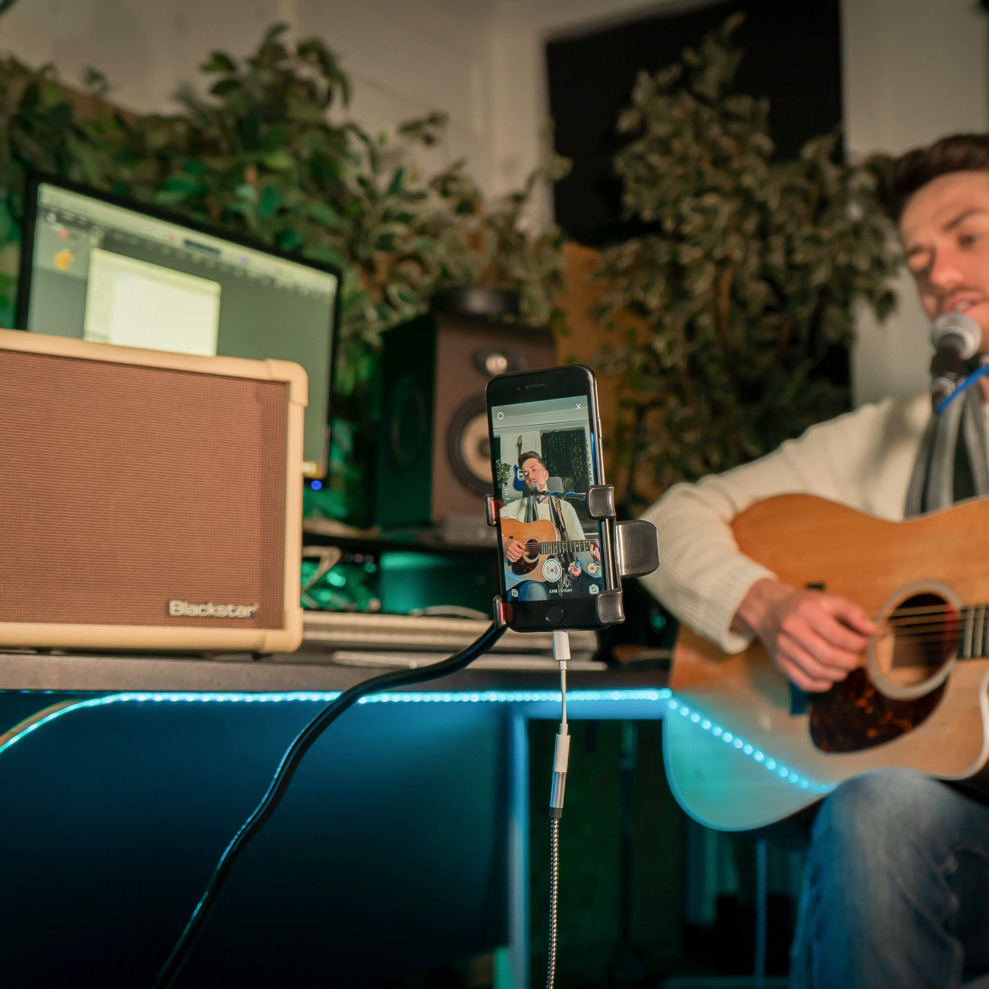 musician playing acoustic guitar plugged into Blackstar Acoustic:CORE 30 guitar amplifier in home recording studio