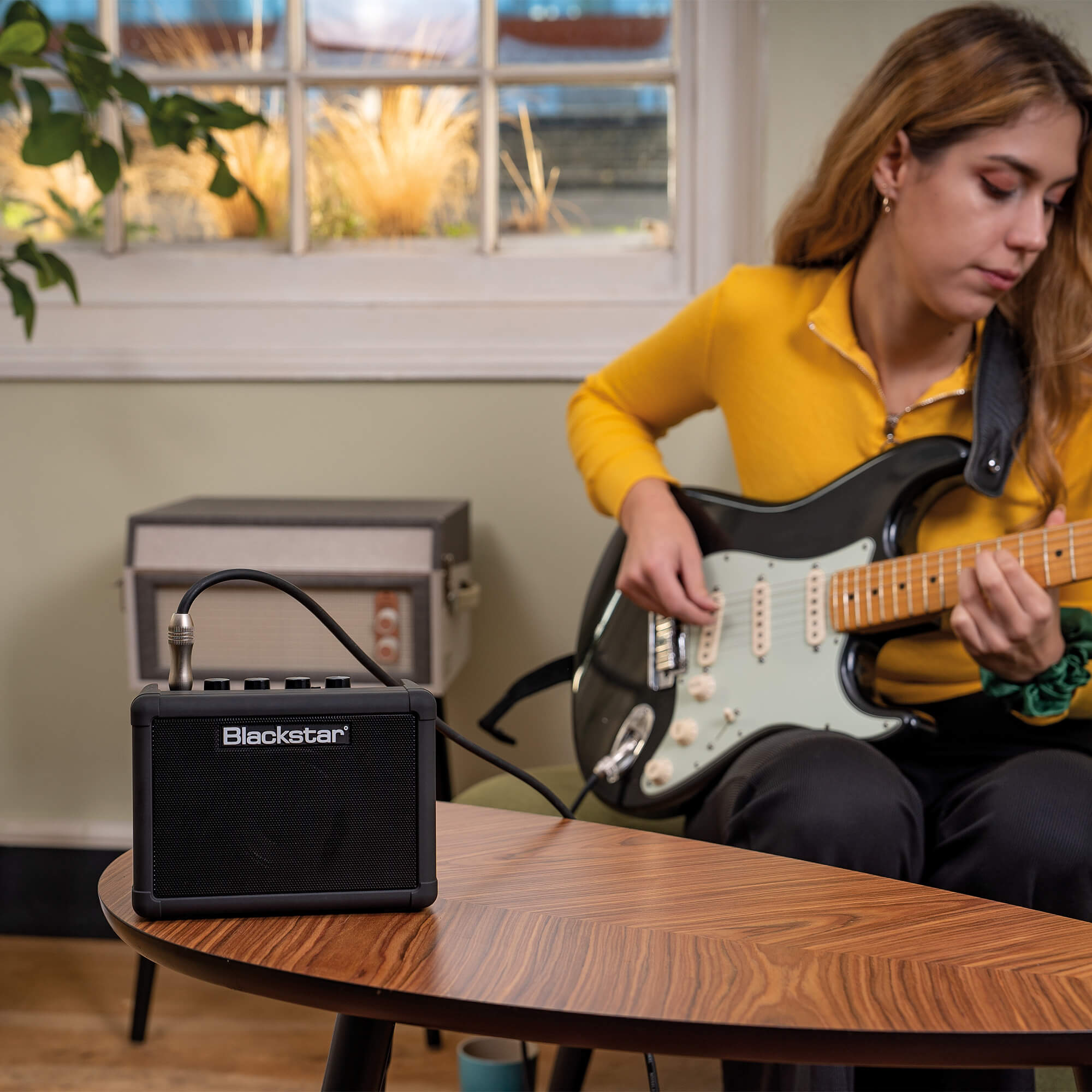 guitar player plugged into Blackstar Amps FLY 3 Charge mini guitar amplifier