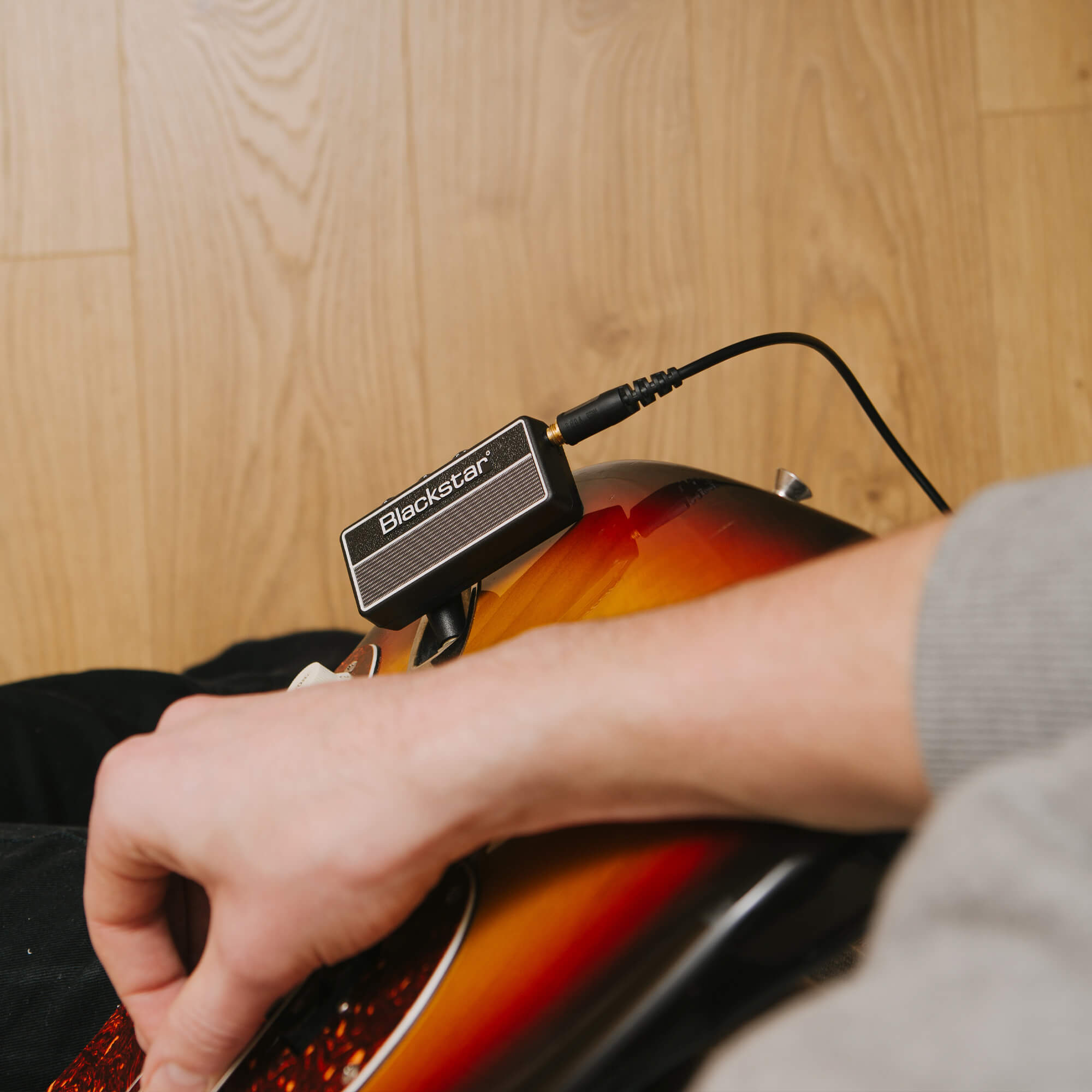 guitar player strumming guitar with Blackstar amPlug 2 FLY guitar amp plugged into guitar and headphones