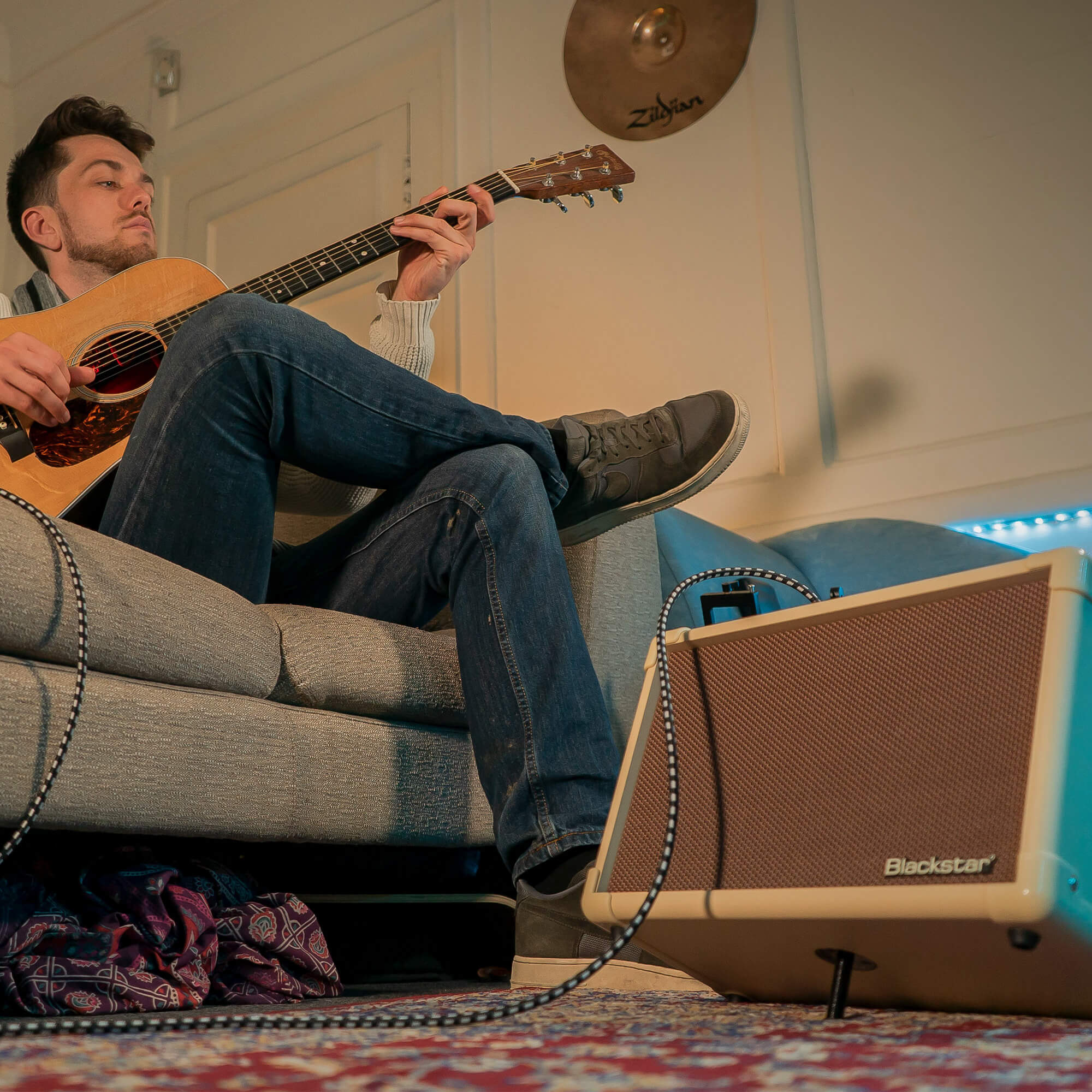 musician playing acoustic guitar plugged into Blackstar Acoustic:CORE 30 guitar amplifier