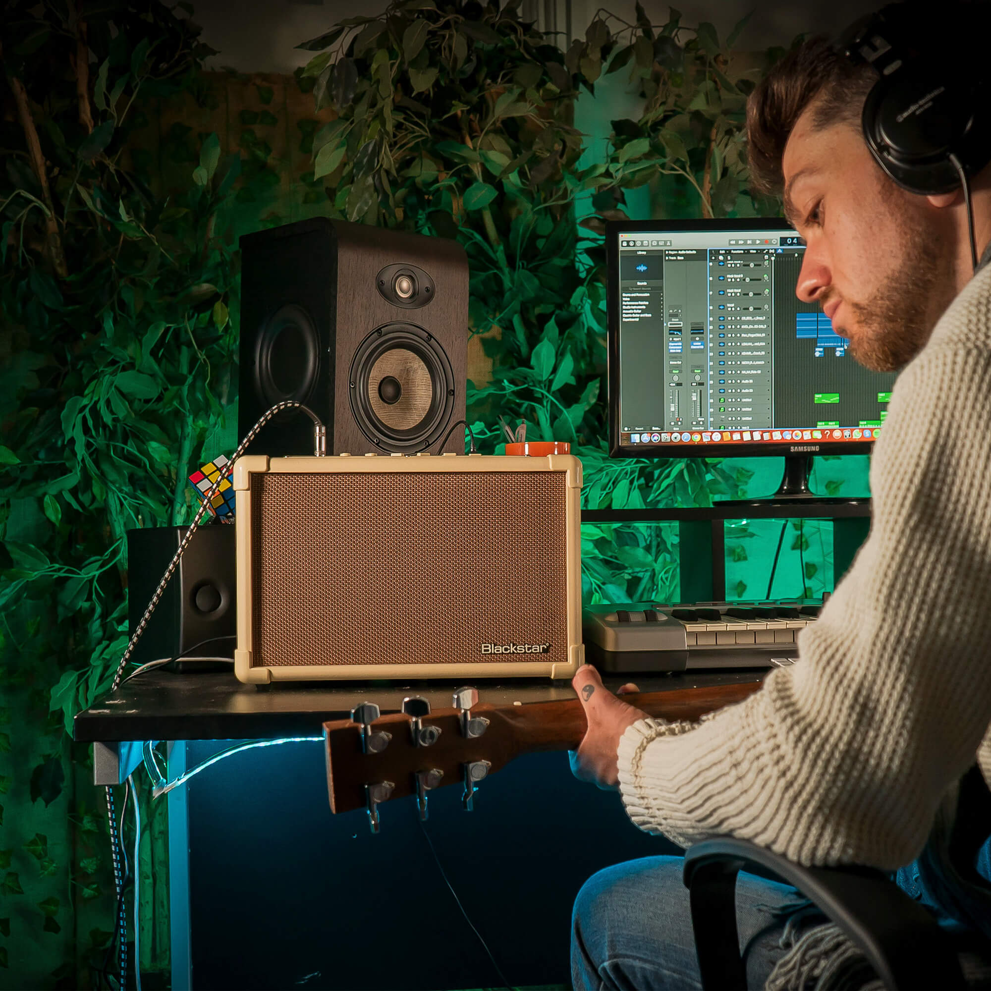 musician playing acoustic guitar plugged into Blackstar Acoustic:CORE 30 guitar amplifier in home recording studio