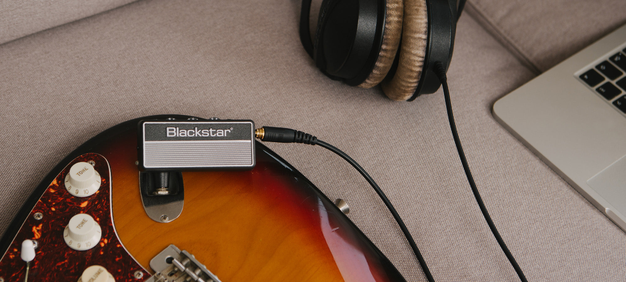 guitar player strumming guitar with Blackstar amPlug 2 FLY guitar amp plugged into guitar and headphones